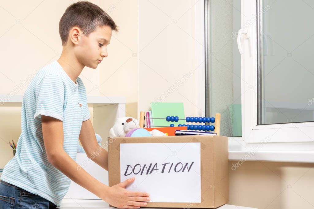 Kid volunteer putting toys, clothes, books, donation goods in donate charity boxes