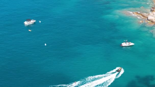 Vista aérea a la hermosa superficie de agua de mar azul profundo con barcos y barcos navegando sobre olas tranquilas. La gente disfruta de un día soleado. Viajes vacaciones verano concepto de vacaciones — Vídeos de Stock