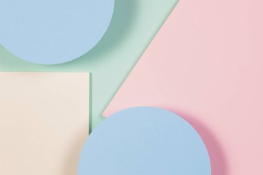 Yumuşak yeşil, pastel pembe, açık mavi, sarı renkli kağıdın soyut geometrik dokusu. Üst manzara, düz uzanma