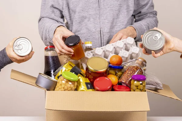 Volontärer händer samla livsmedel, livsmedel till livsmedel donationer box — Stockfoto