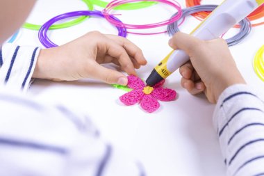 Çocuk eller 3 boyutlu kalemle yeni 3 boyutlu nesneler yaratıyor. Evde öğrenme ve eğlenme. Üst görünüm