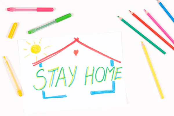 Μείνε σπίτι. Παιδική ζωγραφική εικόνα και εργαλεία σχεδίασης σε λευκό γραφείο. Στο πάνω μέρος. Καραντίνα στο σπίτι κατά τη διάρκεια της πανδημίας του Coronavirus — Φωτογραφία Αρχείου