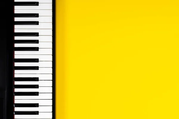 Vista superior al teclado del piano sobre fondo amarillo. Concepto de aprendizaje musical. Vista superior —  Fotos de Stock