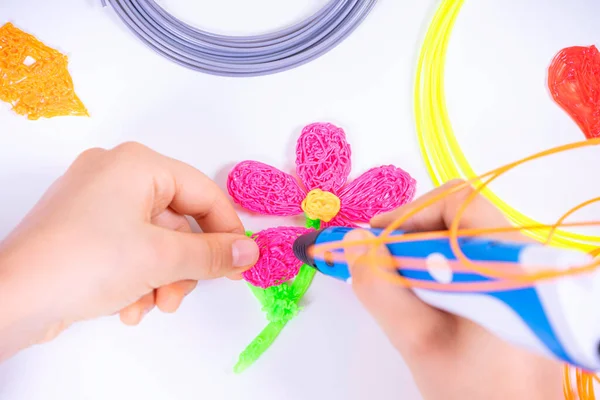 Manos de niño creando con pluma 3d. Aprendizaje y entretenimiento en casa. Vista superior — Foto de Stock