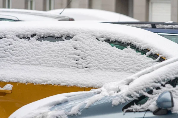 Auta pokrytá sněhem zaparkované ve dvoře bytového domu — Stock fotografie