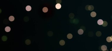 Siyah arkaplanda yeşil ve sarı bokeh ışıkları