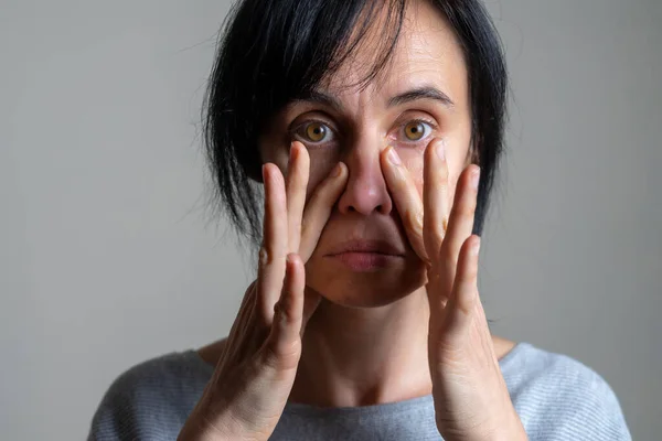 Yoga facial, gimnasia facial, rutina diaria de autocuidado. Mujer caucásica de mediana edad realizando ejercicios faciales en casa — Foto de Stock