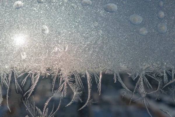Ventana congelada en invierno. Patrón de heladas en la ventana. Flores heladas en un vaso — Foto de Stock