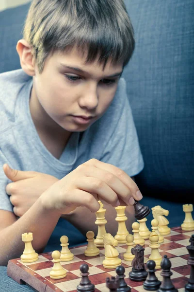 Хлопчик-підліток грає в шахи вдома. Інтернет-освіта, дистанційне навчання, розваги для Childen — стокове фото