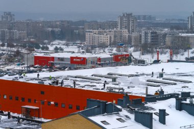 Vilnius, Litvanya - 3 Şubat 2021: İşçiler alışveriş merkezinin çatısını kürekle temizliyorlar