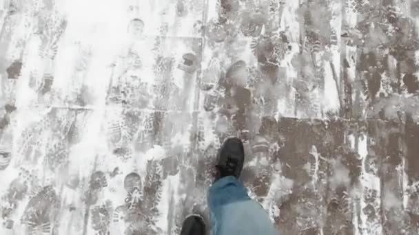 Piernas de hombre caminando sobre la nieve con huellas en el día nevado. Vídeo 4k — Vídeos de Stock