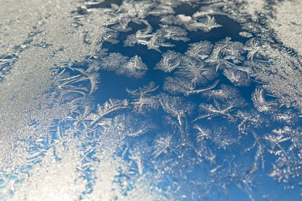 Superficie congelada con patrón de hielo en el vidrio de la ventana en frío día de invierno — Foto de Stock
