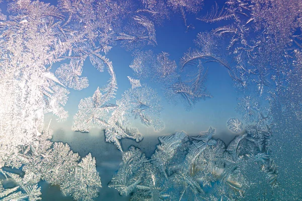 Superficie congelada con patrón de hielo en el vidrio de la ventana en frío día de invierno — Foto de Stock