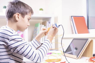 Çocuk 3D kalemle yeni 3D nesne yaratıyor. Evde öğrenim ve eğlence