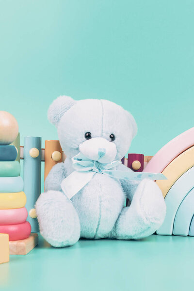 Детская коллекция игрушек. Медвежонок, деревянная радуга, самолет, образовательные и музыкальные детские игрушки на светло-голубом фоне