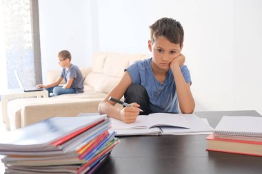 Çocuklar evde ödev yapıyor. Çevrimiçi öğrenme, uzaklık öğrenme, evde eğitim, evde kalma kavramı