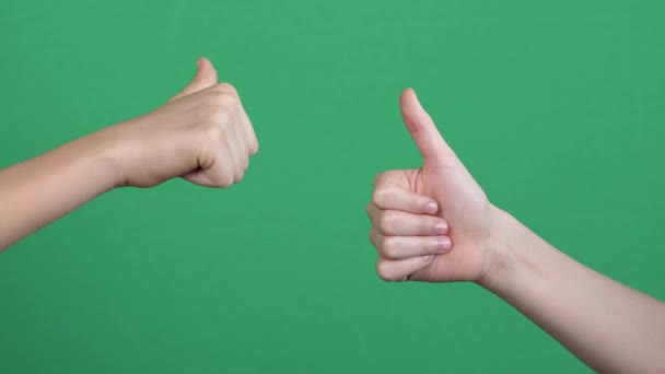 Like dislike gestures. Two hands showing different signs thumbs up and thumbs down over green screen background. — Wideo stockowe