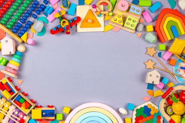 Oyuncak bebek çerçevesi. Renkli eğitici ahşap plastik ve gri arka plandaki çocuklar için tüylü oyuncaklar. Üst manzara, düz uzanma