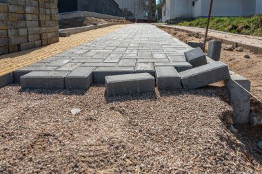Evin girişine gri beton döşeme döşeme döşemesi. Kaldırım döşenmiş tuğlalı kaldırım inşaatı, yarı döşenmiş kaldırım yolu.