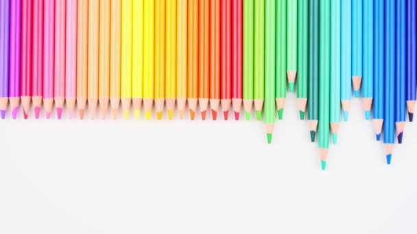 Kolorowe ołówki rozmieszczone na białym tle rozciągają się w górę i w tył. Widok góry. Stop animacji ruchu, edukacji, uczenia się, sztuki, powrót do koncepcji szkoły — Wideo stockowe