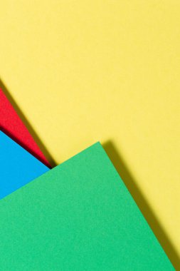 Soyut renk kağıtları geometri düz kompozisyon arkaplan mavi, sarı, kırmızı ve yeşil renk tonlarıyla