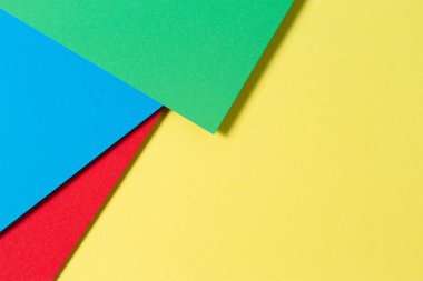 Soyut renk kağıtları geometri düz kompozisyon arkaplan mavi, sarı, kırmızı ve yeşil renk tonlarıyla