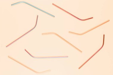 Pastel arka planda çok renkli paslanmaz çelik pipetler. Üst görünüm