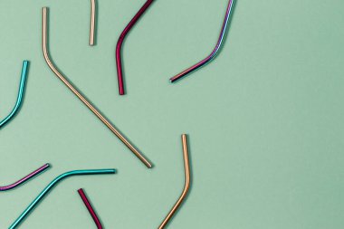 Environmental friendly stainless steel reusable drinking straws on pastel background. Top view