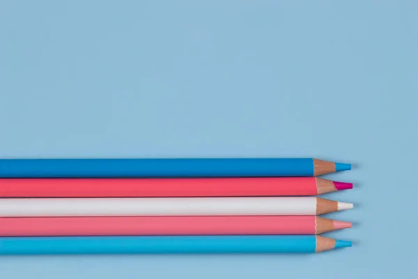 Lápices de colores sobre fondo azul claro. Pastel rosa, azul, colores blancos. Vista superior — Foto de Stock