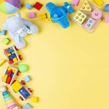 Renkli eğitici ahşap plastik ve pastel sarısı arka plandaki çocuklar için tüylü oyuncaklar. Üst manzara, düz uzanma