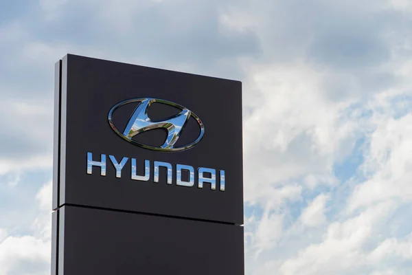 Hyundai brand logo on the stand near car dealership company against the blue sky. Hyundai is a South Korean car manufacturer headquartered in Seoul, South Korea — Stock Photo, Image