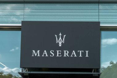 Vilnius, Lithuania - May 12, 2021: Maserati logo and signboard on official dealership showroom building. Maserati is famous Italian luxury vehicle manufacturer clipart
