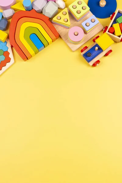 Oyuncak bebek çerçevesi. Eğitici ahşap plastik ve sarı arka plandaki çocuklar için yumuşak oyuncaklar. Üst manzara, düz uzanma — Stok fotoğraf