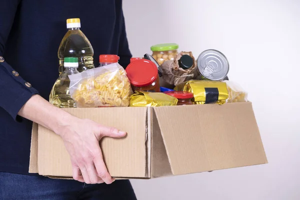 Woman volunteer hands holding food donations box with food grocery products — Stock Photo, Image