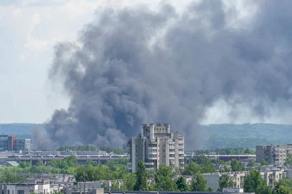 Şehirde yangın var. Şehir binalarının üzerinden gökyüzüne yükselen siyah duman sütunu