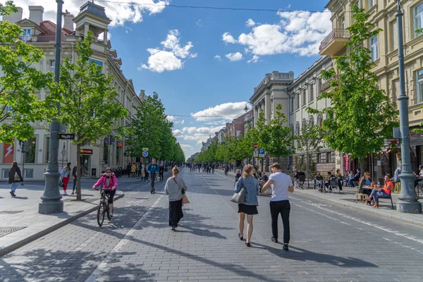 Vilna, Lituania - 30 de mayo de 2021: Vista a la calle principal de la ciudad de Vilna - Avenida Gedimino, Catedral de Vilna y campanario con personas caminando y montando en bicicleta en un día soleado — Foto de Stock