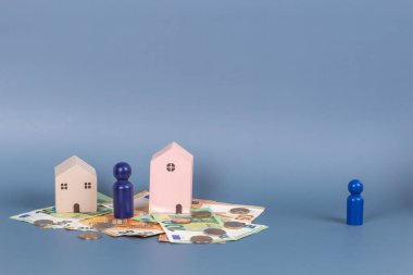 Boşanma, anlaşmazlık, aşkı bozma, ortaklık, mülkiyet bölünmesi. Eski çift. Eşcinsel bir çifti ayırmak. Ahşap evler, para, gri arka planda minyatür figürler