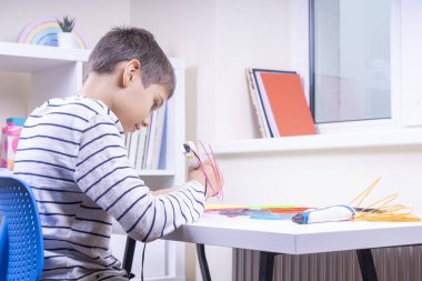 Genç çocuk 3 boyutlu kalemle yeni 3 boyutlu nesneler yapıyor. Evde öğrenim ve eğlence