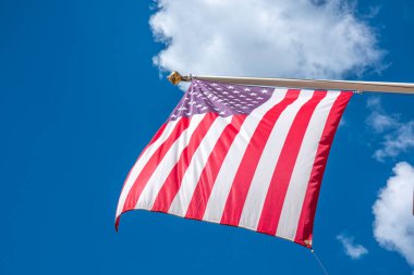 Mavi gökyüzünde sallanan Amerika Birleşik Devletleri bayrağı. Amerikan bayrağına alçak görünüm