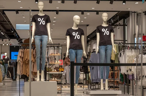 Εποχιακή πώληση. Mannequins φορώντας μαύρα t-shirts με το ποσοστό υπογράψει στέκεται μέσα κατάστημα ρούχων κατά τη διάρκεια της περιόδου πώλησης των αγορών — Φωτογραφία Αρχείου