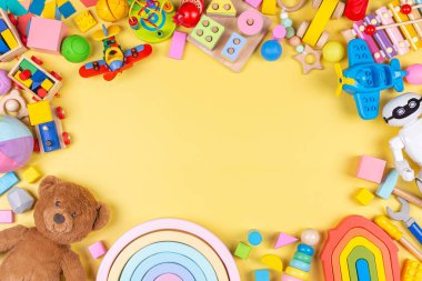 Oyuncak bebek geçmişi. Eğitici ahşap plastik ve pastel sarısı arka plandaki çocuklar için tüylü oyuncaklar. Üst manzara, düz uzanma