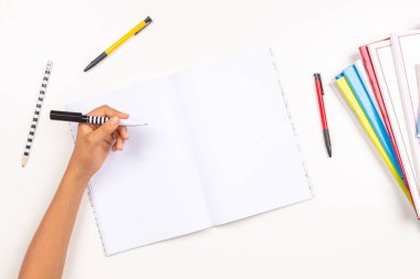 Çocuk kalemi sol elinde tutuyor ve açık bir deftere yazıyor, ödev yapıyor. Solcular Günü