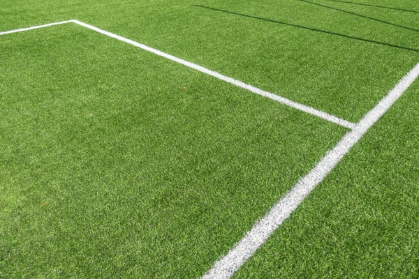 Fußball-Hintergrund. Grüne Kunstrasen Fußball Sportplatz mit weißen Streifen Linien — Stockfoto