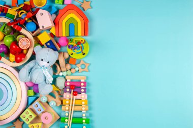 Bebek oyuncakları açık mavi arka planda. Renkli eğitici ahşap ve müzikal oyuncaklar. Üst manzara, düz uzanma