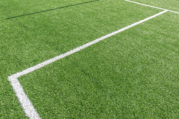 Voetbal achtergrond. Groene kunstgras voetbalveld met witte streep lijnen — Stockfoto