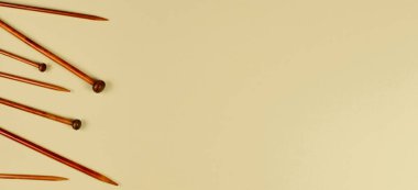 Pastel arka planda ahşap bambu örgü iğneleri. Üst görünüm, alanı kopyala