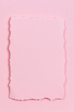 Boş yırtık kağıt parçası, pastel pembe arka planda yırtık kağıt. Üst görünüm