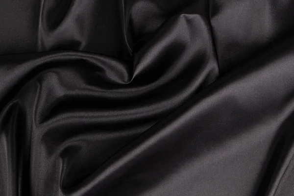 Piękne, eleganckie, czarne tło z draperią i falowanymi fałdami jedwabnej satynowej tkaniny. Widok z góry — Zdjęcie stockowe