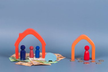 Boşanma, ebeveynler çatışması, çocukların velayeti, mülkiyet bölümü kavramı. Bir ahşap evde anne ve babanın minyatür figürleri.