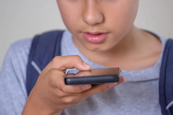 Adolescente menino mantenha o telefone inteligente falando através do microfone, usando a função de reconhecimento de voz do telefone celular on-line, enviando mensagem de voz de gravação — Fotografia de Stock